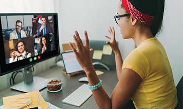 A office worker having online meeting with coworkers during the pandemic