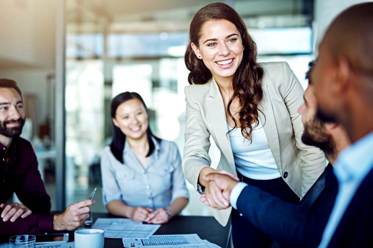 Two businesspeople shaking hands during a meeting in the boardroom