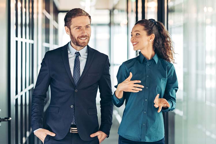 Businessman and businesswoman walking together and talking