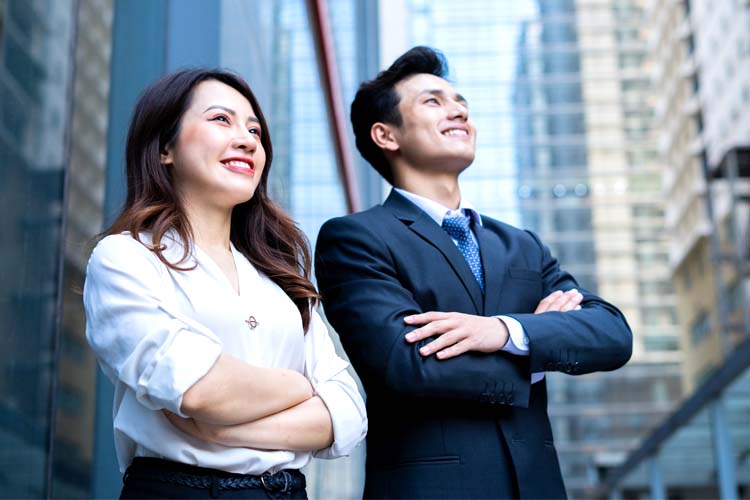 Two business people standing next to each other and smiling.