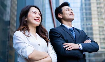 Two business people standing next to each other and smiling.