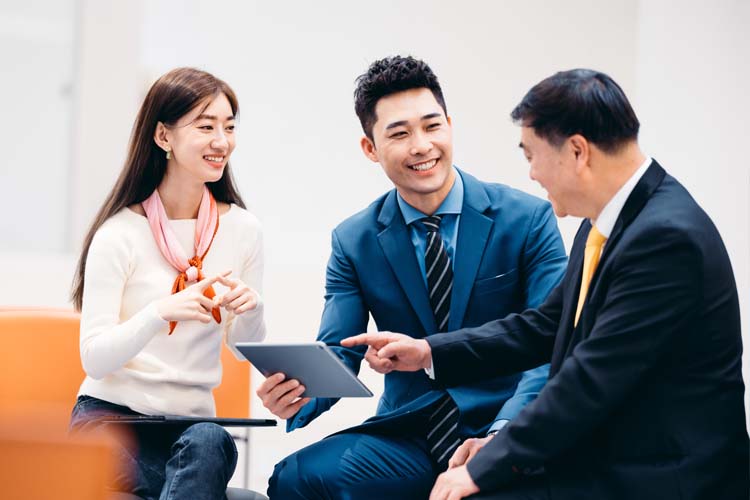 Asian business people discuss in an open working environment.