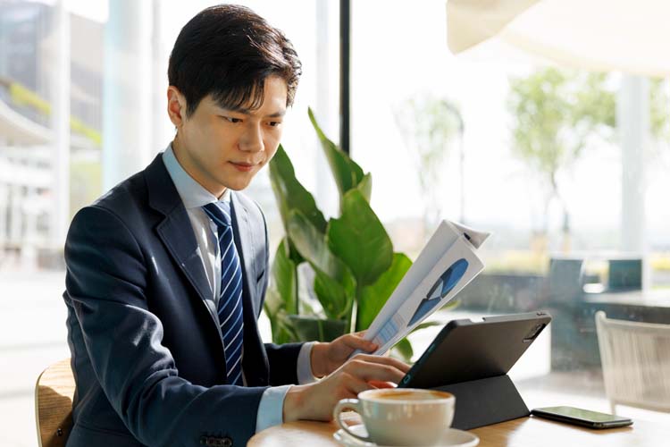 Young Asian businessmen use tablets in café.