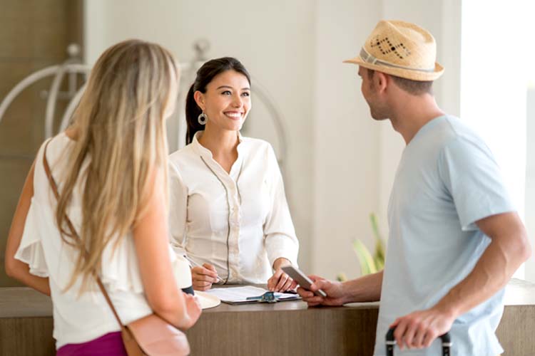 Hotel receptionist doing the check-in of a couple.