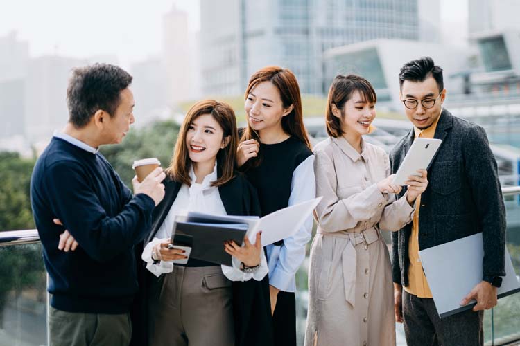 Business professionals with paperwork and digital tablets collaborate on projects in urban skyscrapers.