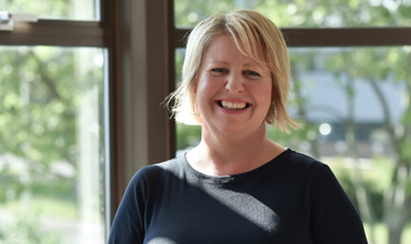 Leanne Cahill is smiling and posing for a portrait.