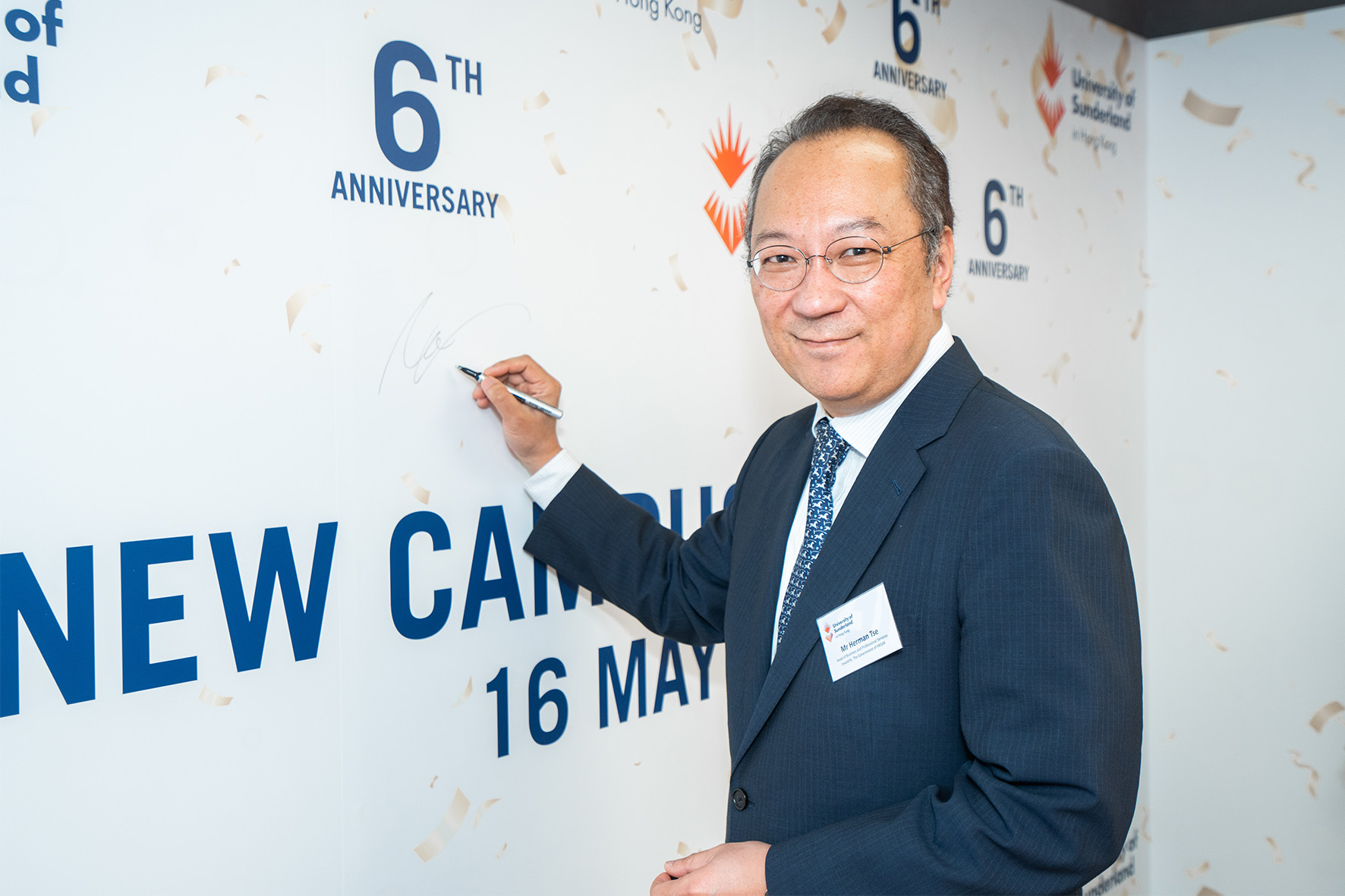 Mr Herman Tse, Head of Business and Professional Services, Invest Hong Kong, The Government of the Hong Kong Special Administrative Region autographed on the signing board for the new campus opening 2023.