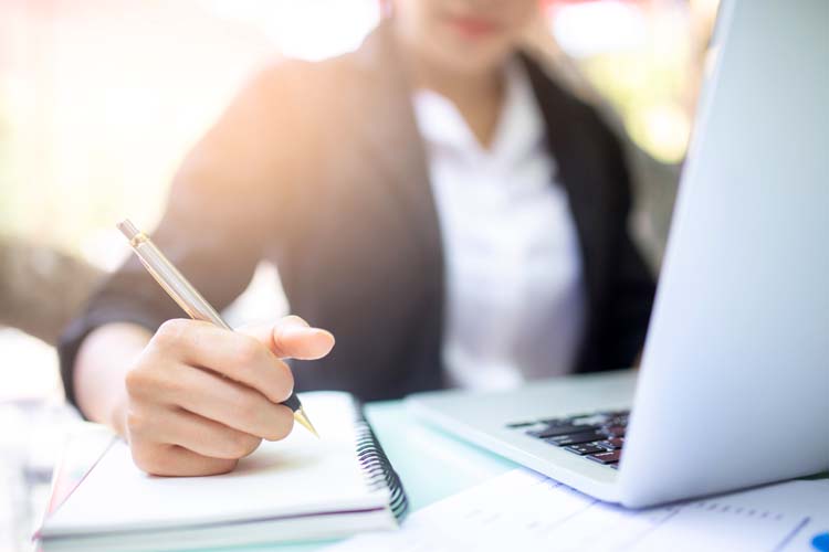 Young woman studying and using computer.