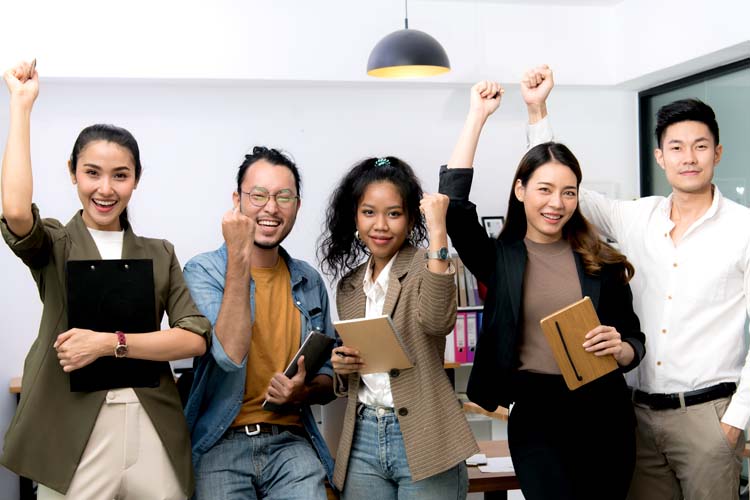 A group of successful young Asian businessmen raising hands.