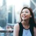Asian business woman standing on the roof of the financial district and looking up to the sky happily.