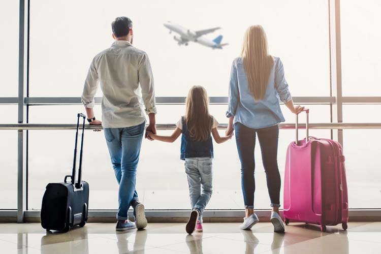 Family in the airport with their suitcase.