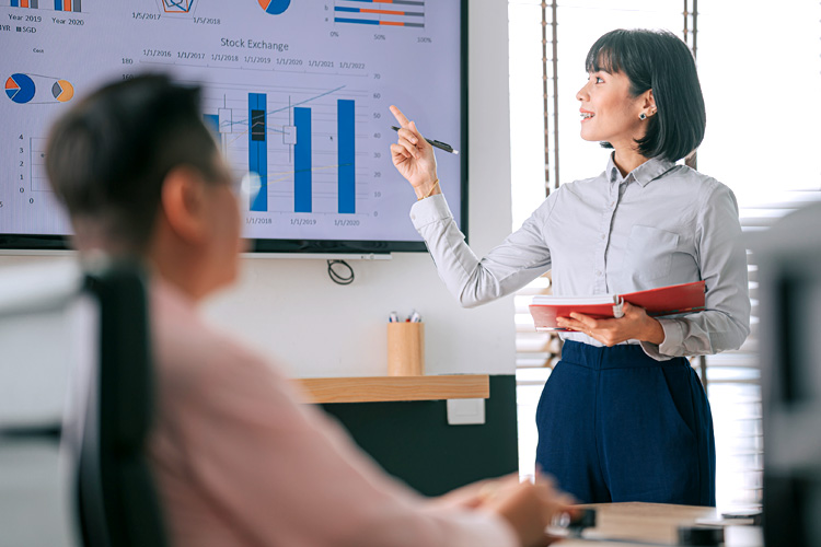 Confident woman with braces presents to colleague in the conference room.