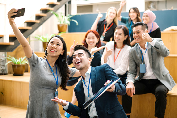 HR captures a joyful moment by taking a selfie alongside their colleague.