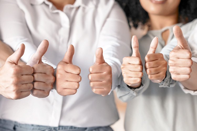 Thumbs up hands for teamwork, motivation and support at the company office.