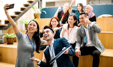 HR captures a joyful moment by taking a selfie alongside their colleague.