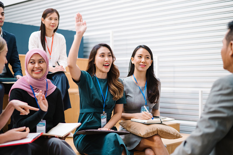 Asian businesswoman asking question during a seminar.
