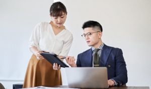 The woman asks the business mentor to review the materials.