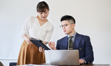 The woman asks the business mentor to review the materials.