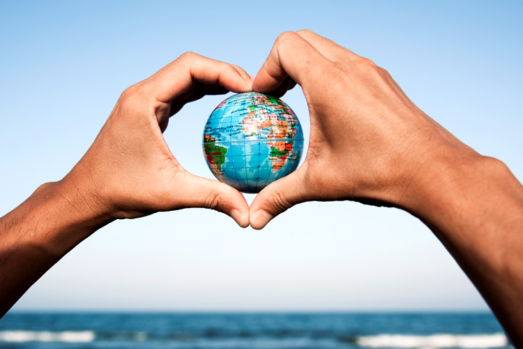 A young person holding a globe in their hands.