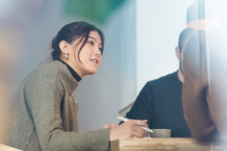 Employer interviewing a job applicant inside office boardroom.