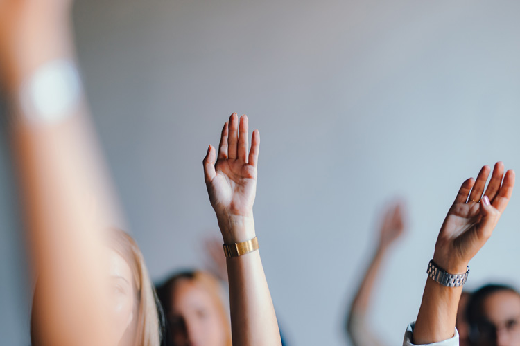 Group of People Raising Hands in a Business Meeting.