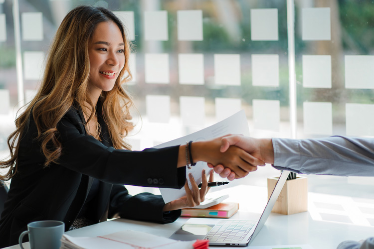 Two confident businessmen shaking hands during the meeting.