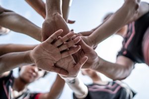 Close-up of female soccer team stacking hands in the field.