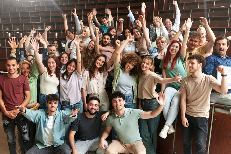 Crowd of happy students celebrating the end of school year in amphitheater.